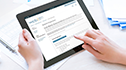 Workers can submit claim expenses online, women using WCB online services on tablet