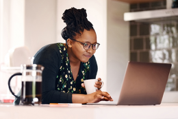 WCB Online account, woman at computer smiling