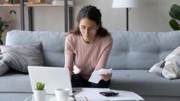Serious female managing family finances using laptop